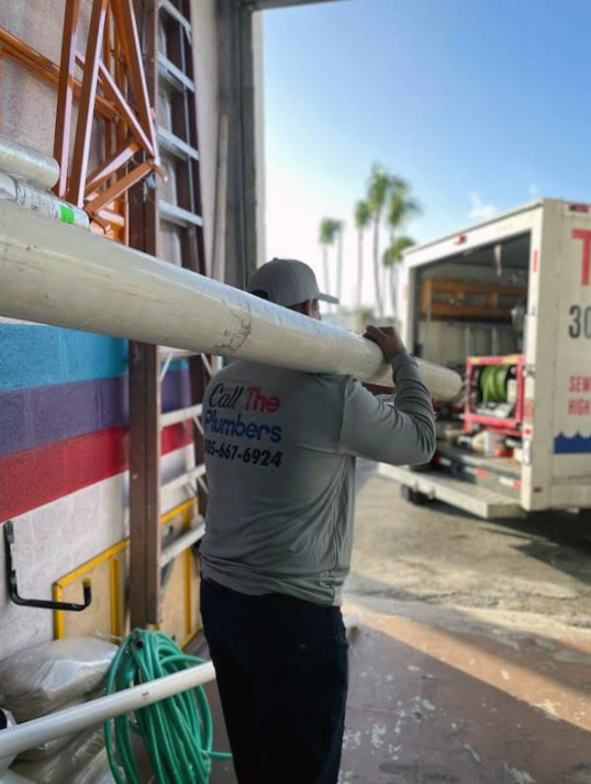 Plumbers moving sewer pipe materials