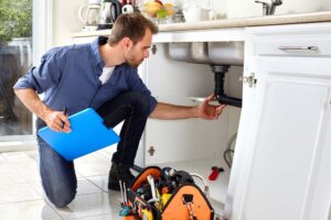 plumber inspecting a leaking pipe